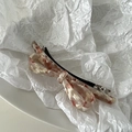 Close-up of acetate bow hair clip with pink and brown marble texture on white disc - White Pink