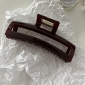 Vue détaillée de la pince à cheveux rectangulaire marron foncé avec ressort doré en métal - Café Rouge