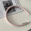 Dettaglio del cerchietto imbottito rosa chiaro con trama satinata su fondo bianco - Rosa