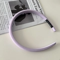 Dettaglio di un cerchietto in tessuto viola chiaro con etichetta fatta a mano su tavolo - Viola