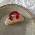 Macro view of milk tea marble texture acetate hair claw clip in handbag shape - Red Handle