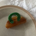 Détail d'une pince à cheveux ambre avec poignée verte et motifs de chiffres dorés - Marron