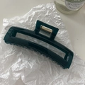 Close-up of a glossy dark green rectangular hair claw clip with a strong gold metal spring - Teal