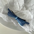 Detail view of a translucent blue acetate bow hair clip with elegant pearlescent finish - Blue