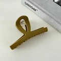 Close-up of olive green acetate hair claw clip with crossed loop and metal spring mechanism - Mustard Green