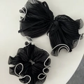 Detalle de coletero de malla plisada negra y pinza de lazo grande con borde blanco en contraste - Goma de pelo negra