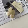 Set de dos pinzas para el cabello color crema con corazones de mármol sobre una revista - Amarillo