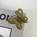Close-up of translucent butterfly hair claw clip with a strong gold metal spring - Green