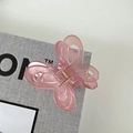 Dettaglio molletta per capelli a farfalla rosa con trama gelatina e molla dorata lucida - Rosa