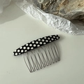 Close-up of retro black and white polka dot hair comb with ten silver metal teeth - Dots