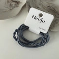 Detailopname van grijsblauwe gedraaide elastische haarelastiekjes op witte displaykaart - Blauw