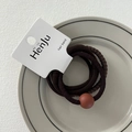 Close-up of coffee brown elastic hair bands with bead detail on display card - Round Bead Coffee