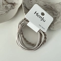 Detailopname van beige elastische haarelastiekjes op kaartverpakking met marmeren blad - Abrikoos