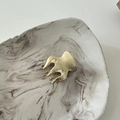 Macro detail of a matte gold metal hair claw clip with a refined brushed texture finish - Skeleton Gold