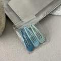 Detailaufnahme von 3 matten Haarspangen in blauen Farbverläufen auf einem Tablett - Hellblau - Tropfenform