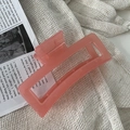 Vista de primer plano de una pinza para el cabello rectangular rosa chicle sobre tela - Rojo Sandía