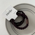 Close-up of brown elastic hair bands with handmade leather tags on white ceramic plate - Leather Patch Coffee