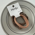 Detail of high-elasticity brown hair bands on a display card in a ceramic plate - Leather Patch Light Coffee