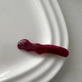 Makroaufnahme einer weinroten wellenförmigen Haarspange aus Harz mit Marmorstruktur - Entenschnabel-Haarclips / Rot