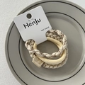 Macro view of cream-colored elastic hair bands with texture and handmade fabric labels - Leather Patch Beige