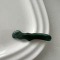 Detailansicht der dunkelgrünen gewellten Haarspange aus Harz mit Marmortextur auf Keramik - Entenschnabel-Haarclips / Grün