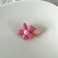 Detail shot of a cute pink floral hair clip with glossy finish on white ceramic plate - Rose Pink Floral