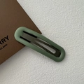 Detalle de pinza para el pelo verde Morandi con textura mate y estructura metálica - Verde