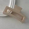 Detailed view of an oversized matte beige rectangular claw clip on a ceramic tray - Milk White