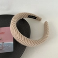 Détail du bandeau en maille beige avec étiquette faite main sur surface mate - Café Clair Tricoté