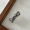 Detail of acetate bow hair clip with black and white marble pattern and gold metal base - Speckled White
