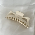 Dettaglio macro della pinza per capelli cava bianco crema con scritta Barrette La France oro - crema