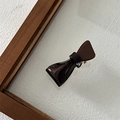 Detail view of brown acetate irregular bow hair clip showing glossy resin and metal clip - Brown