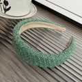 Green knit headband with shiny threads detail on a textured glass surface - Padded Headband / Green