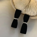 Elegante paio di orecchini a fiocco in velluto nero con perle su piatto bianco - Piccolo Fiocco di Perle