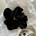 Close-up of a large black velvet hair scrunchie with soft texture on white paper background - Black