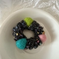 Détail d'élastique cheveux en fil de téléphone en peluche avec pompons colorés sur plateau - Style Balle de Laine / Noir