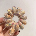 Texture détaillée de l'élastique spirale marron clair pelucheux avec fibres colorées - Bague unie / Abricot