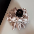 Detailed view of champagne pleated fabric hair claw clip with white pearls decoration - Beige
