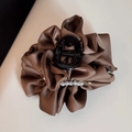 Close-up of brown satin flower hair claw clip with white pearls and golden logo detail - Brown