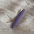 Detailansicht einer lila gestrickten ovalen Haarklammer auf beigem Leinenstoff - Violett Ovaler Clip