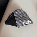 Close-up of black and white checkered fabric with contrast stitching and branded label - Gingham Wavy Edge Triangle Clip