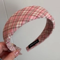 Detailaufnahme eines breiten rosa karierten Stirnbandes mit handgefertigtem Etikett - Rosa