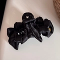 Detail view of large black satin hair claw clip with elegant multi-layer ribbon and gold button - Black