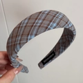 Detail view of a plaid wide headband showing textured fabric and a handmade inner label - Blue Coffee