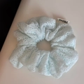 Detail of light blue mesh lace scrunchie featuring a white FMdrea brand fabric label - Blue