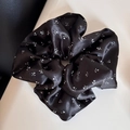 Gros plan sur chouchou en satin noir à fleurs avec texture soyeuse et motifs blancs - Chouchou Satin Floral Large Noir