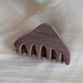 Detail of elegant mauve triangular hair claw clip on white textured fabric background - Khaki
