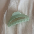Dettaglio ravvicinato di una molletta per capelli verde chiaro su sfondo in tessuto bianco - Pinza Arco Cavo-Verde