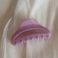 Gros plan d'une pince à cheveux violet clair sur un fond de tissu blanc texturé - Pince Arc Creux-Rose Vif
