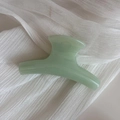 Detail of mint green candy-colored hair claw clip with smooth translucent resin texture - Green